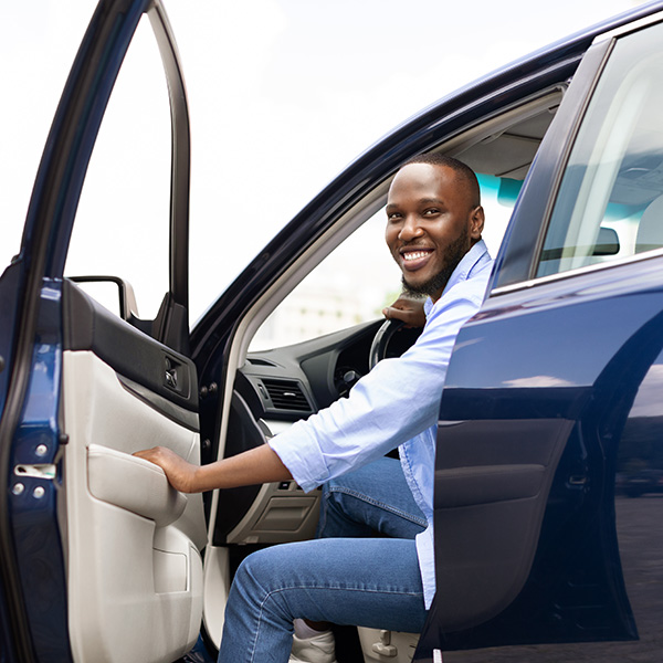 A man sitting in a blue car