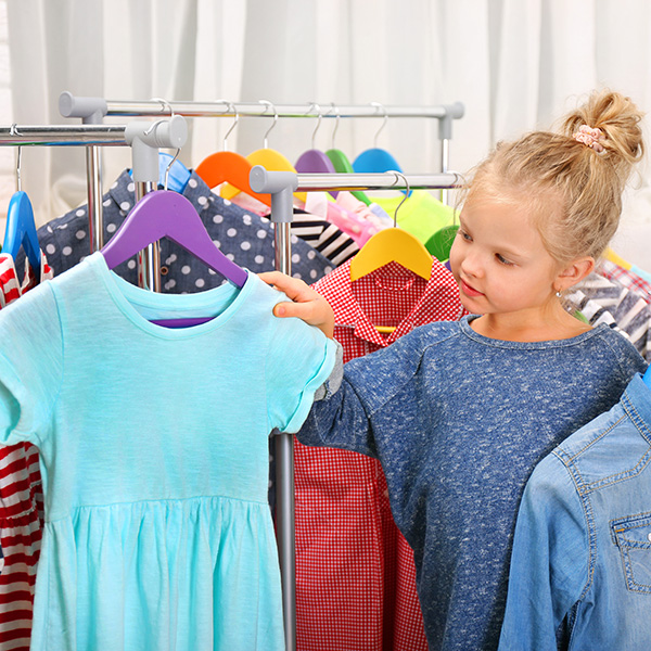 A girl holding two shirts