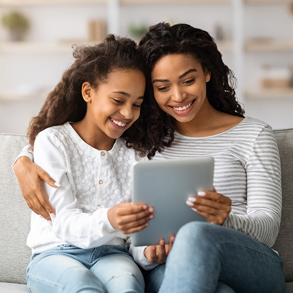Happy mom and daughter looking at a tablet