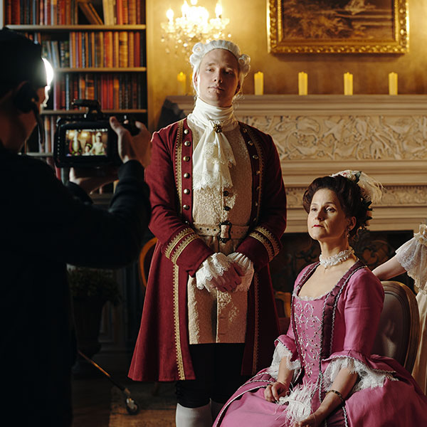 Actors on a movie set with Victorian era production design