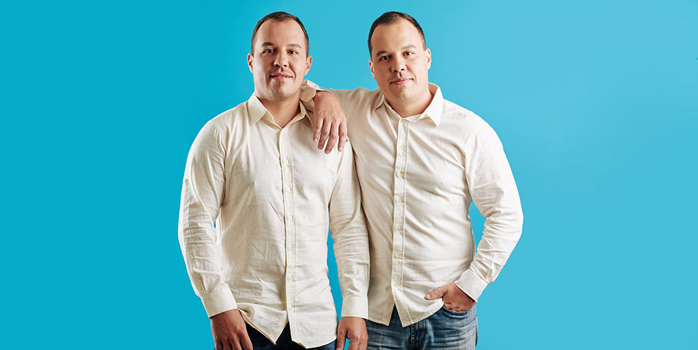 A male photo double standing next to an identical looking actor