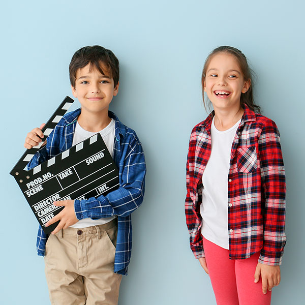 A girl and boy background actor with a clapperboard