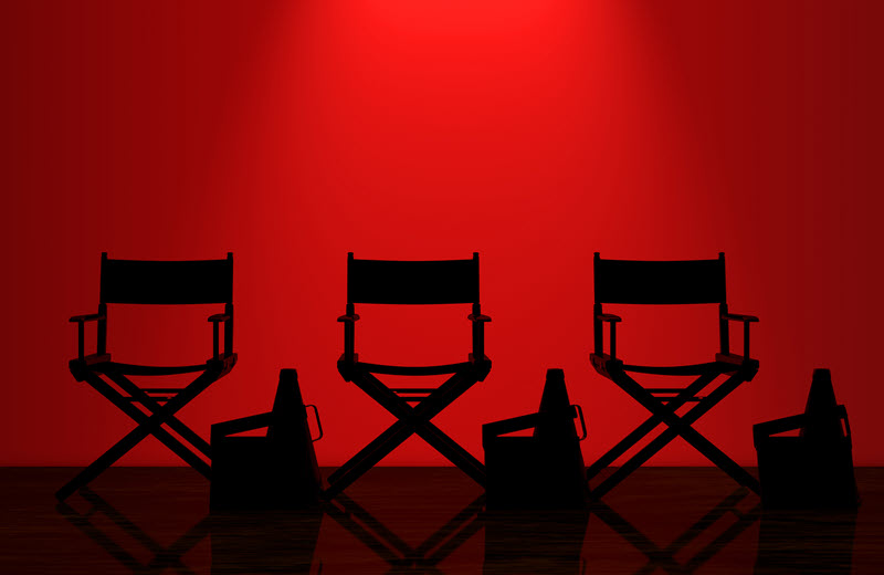 Silhouettes of director's chairs and megaphones against a red background representing film and television production