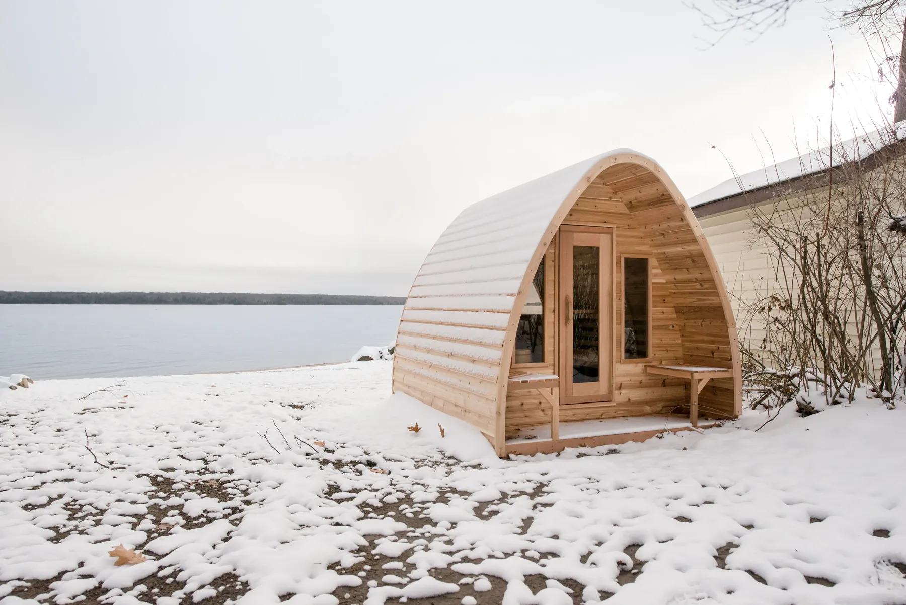 LeisureCraft POD sauna in cedar with an organic rain-drop shape, set against a Canadian winter landscape