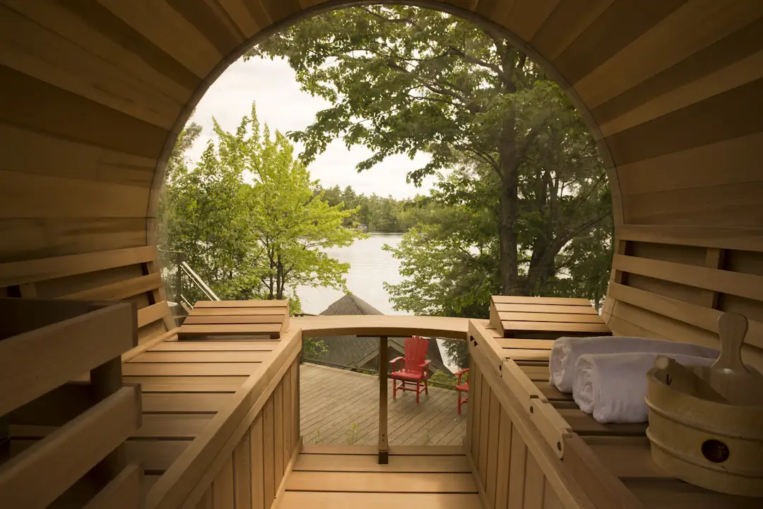 View of the lake through the dome window of a LeisureCraft Panoramic Barrel Sauna, from the cedar benches inside