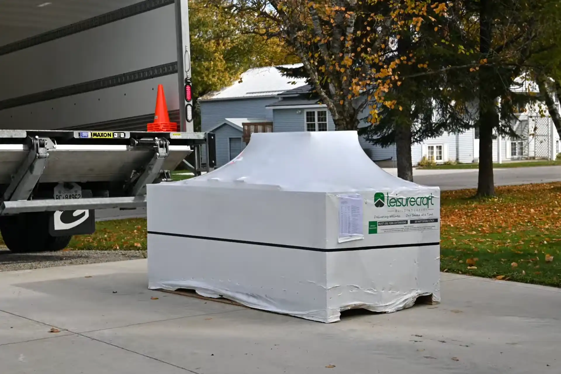 LeisureCraft sauna kit crate delivered and shrink-wrapped in a driveway