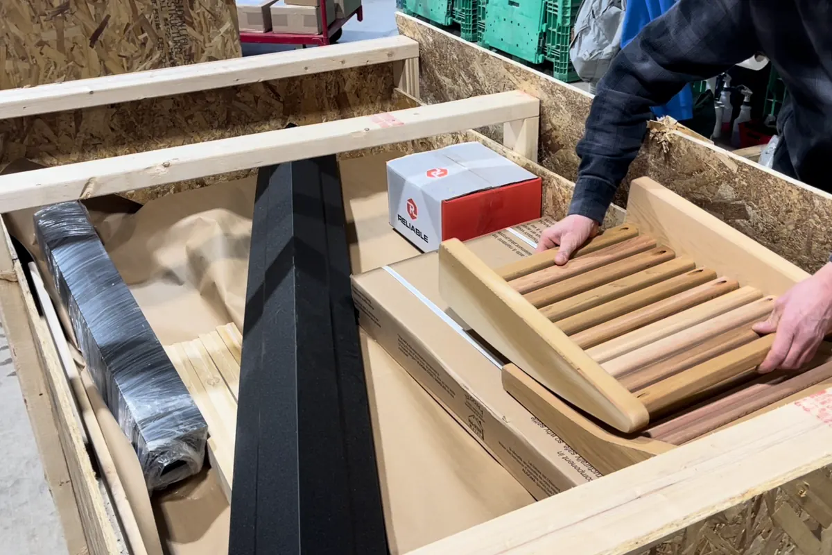 LeisureCraft staff packing sauna kit parts and hardware into a shipping crate