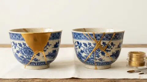 Cuencos de cerámica reparados con Kintsugi que ilustran la reparación de relaciones, los beneficios de la terapia de pareja online y la sanación matrimonial.