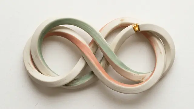 Interlocked ceramic loop representing recurring relationship conflict and the cycle of arguments in couples therapy.