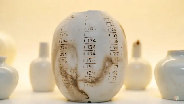 White ceramic jar with geometric lines next to a metal ruler, illustrating a couples therapy review, app price value calculation, and marriage assessment tools like the Lasting app.
