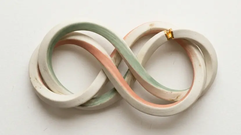 Interlocked ceramic loop representing recurring relationship conflict and the cycle of arguments in couples therapy.