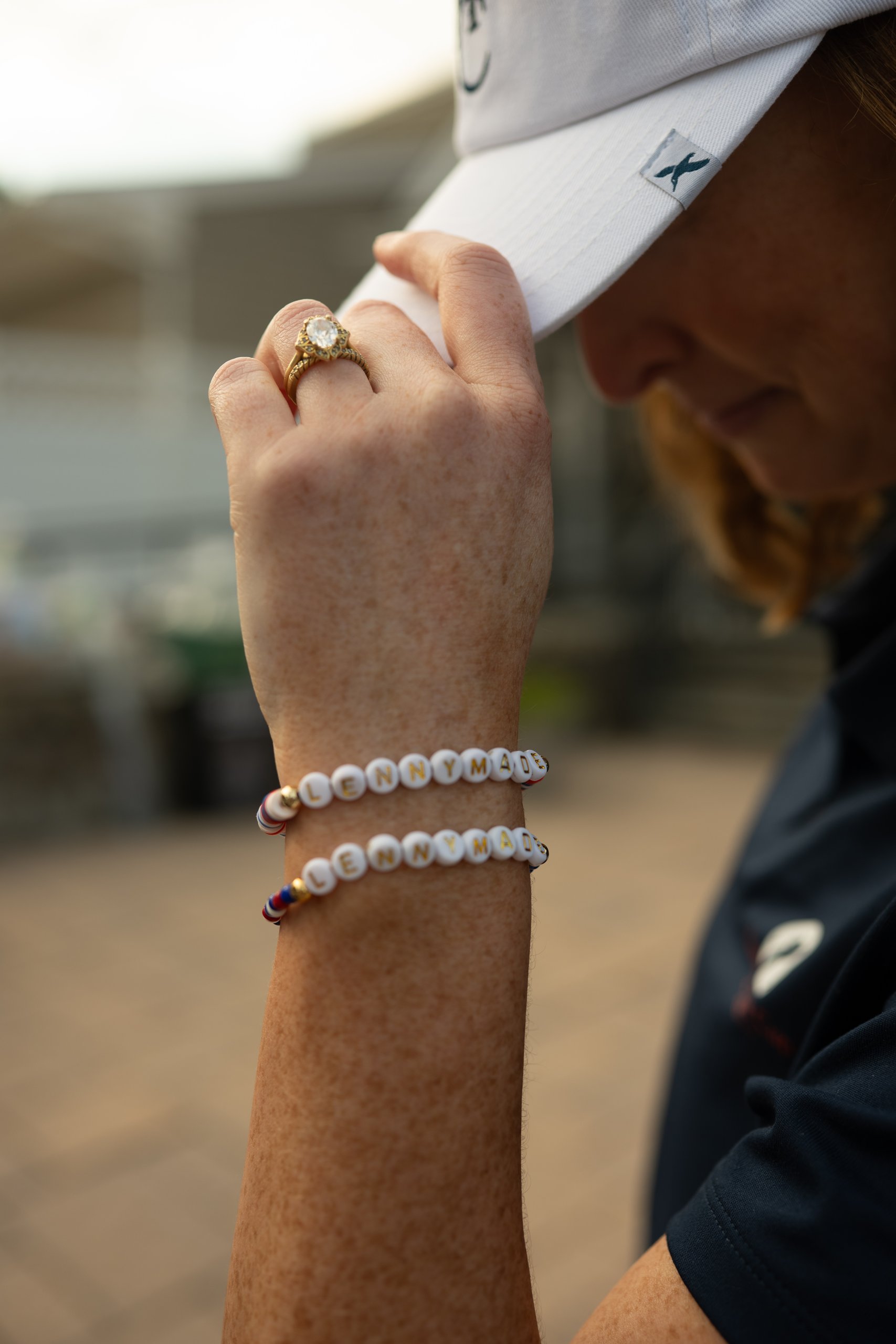 Close-up of a woman's wrist wearing two white beaded LENNYMADE bracelets and a gold ring.