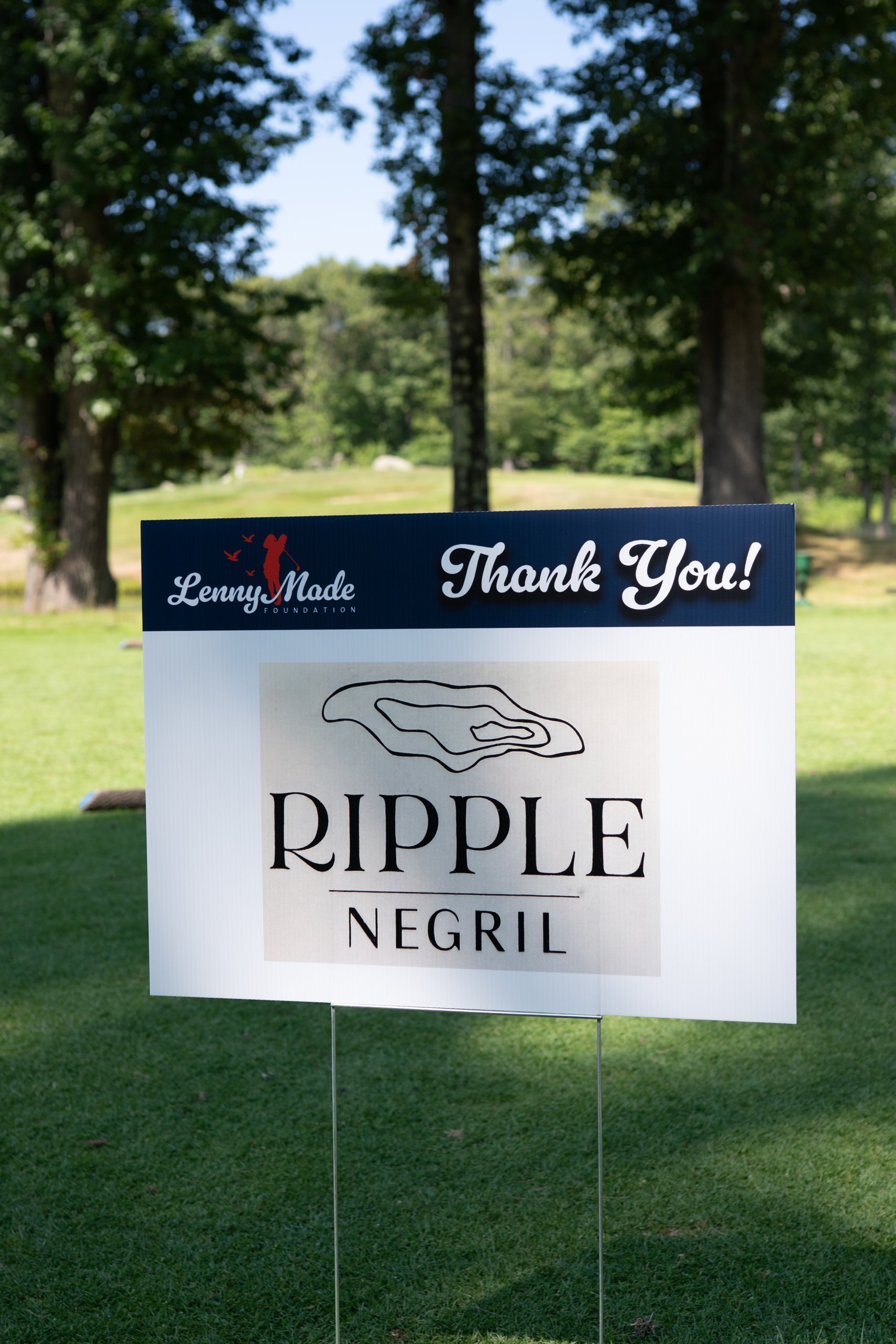 A LennyMade Foundation Thank You sponsor sign for Ripple Negril staked on the grass.