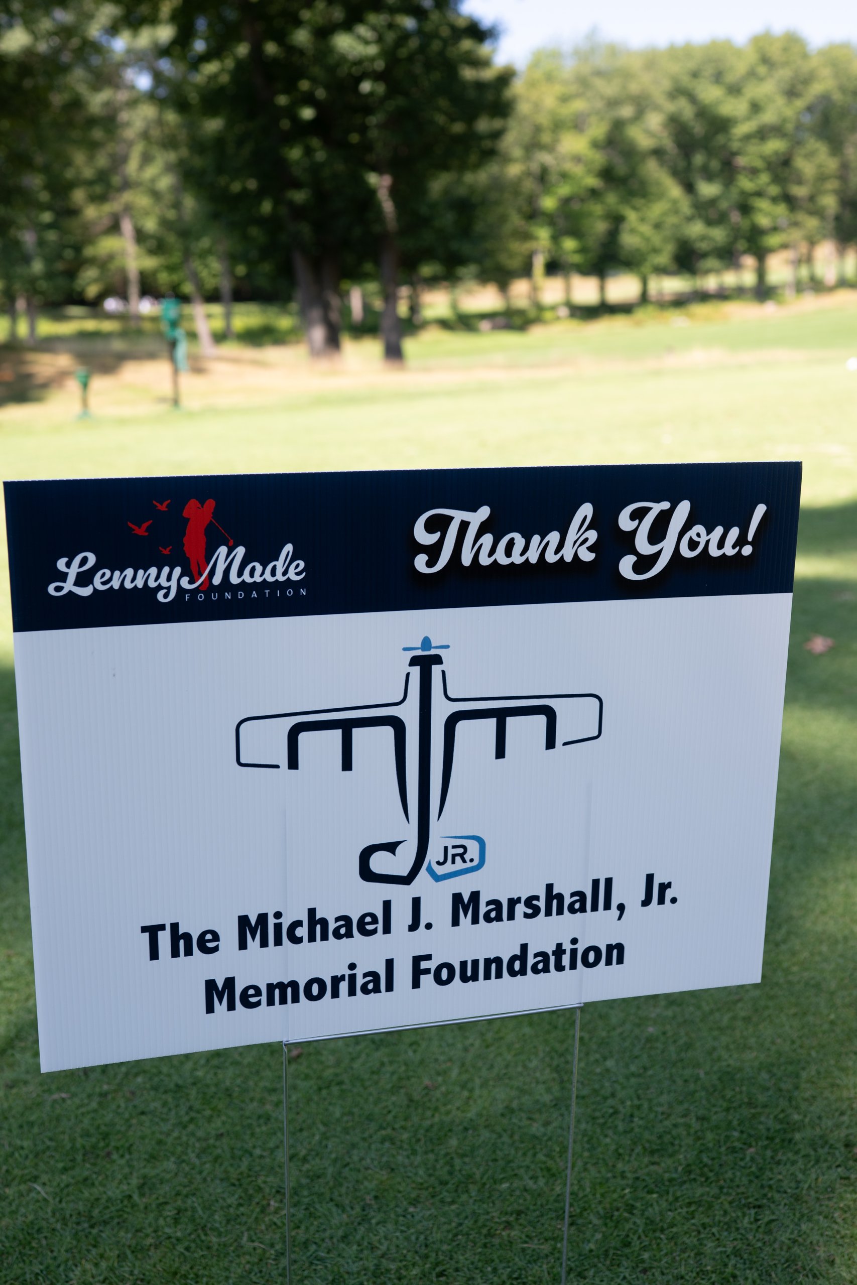 A LennyMade Foundation Thank You sponsor sign for The Michael J. Marshall, Jr. Memorial Foundation on the course.