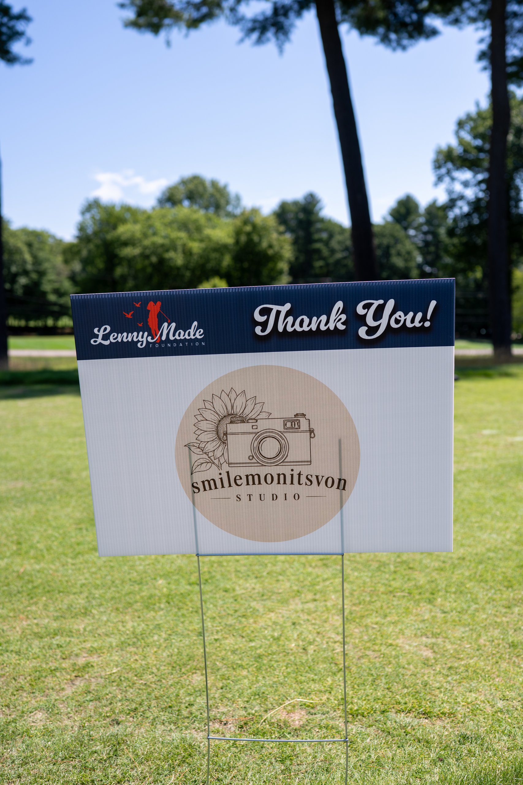 A LennyMade Foundation Thank You sponsor sign for Smilemonitsvon Studio, with its camera-and-sunflower photography logo.