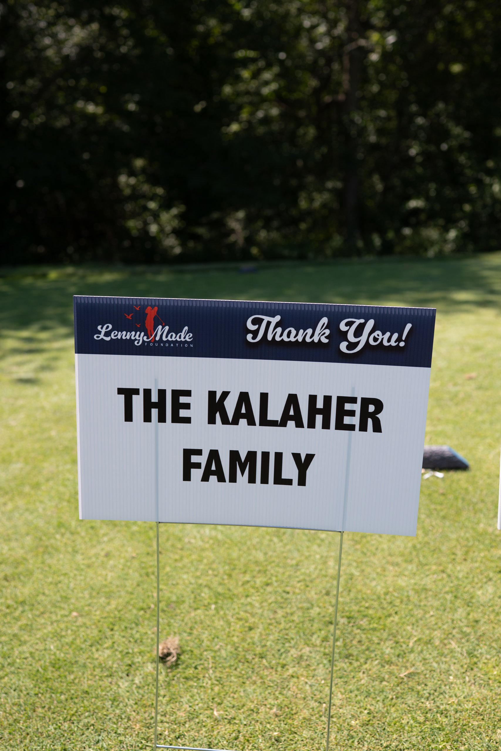 A LennyMade Foundation Thank You sponsor sign for The Kalaher Family on the course.