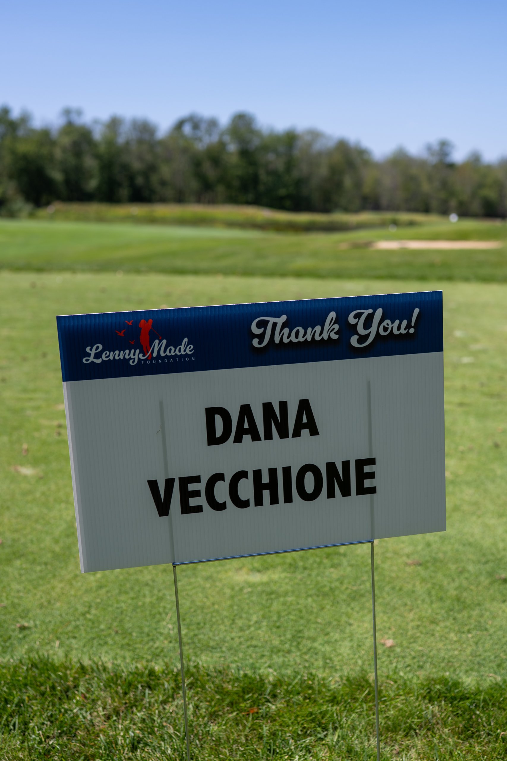 A LennyMade Foundation Thank You sponsor sign for Dana Vecchione staked on the fairway.