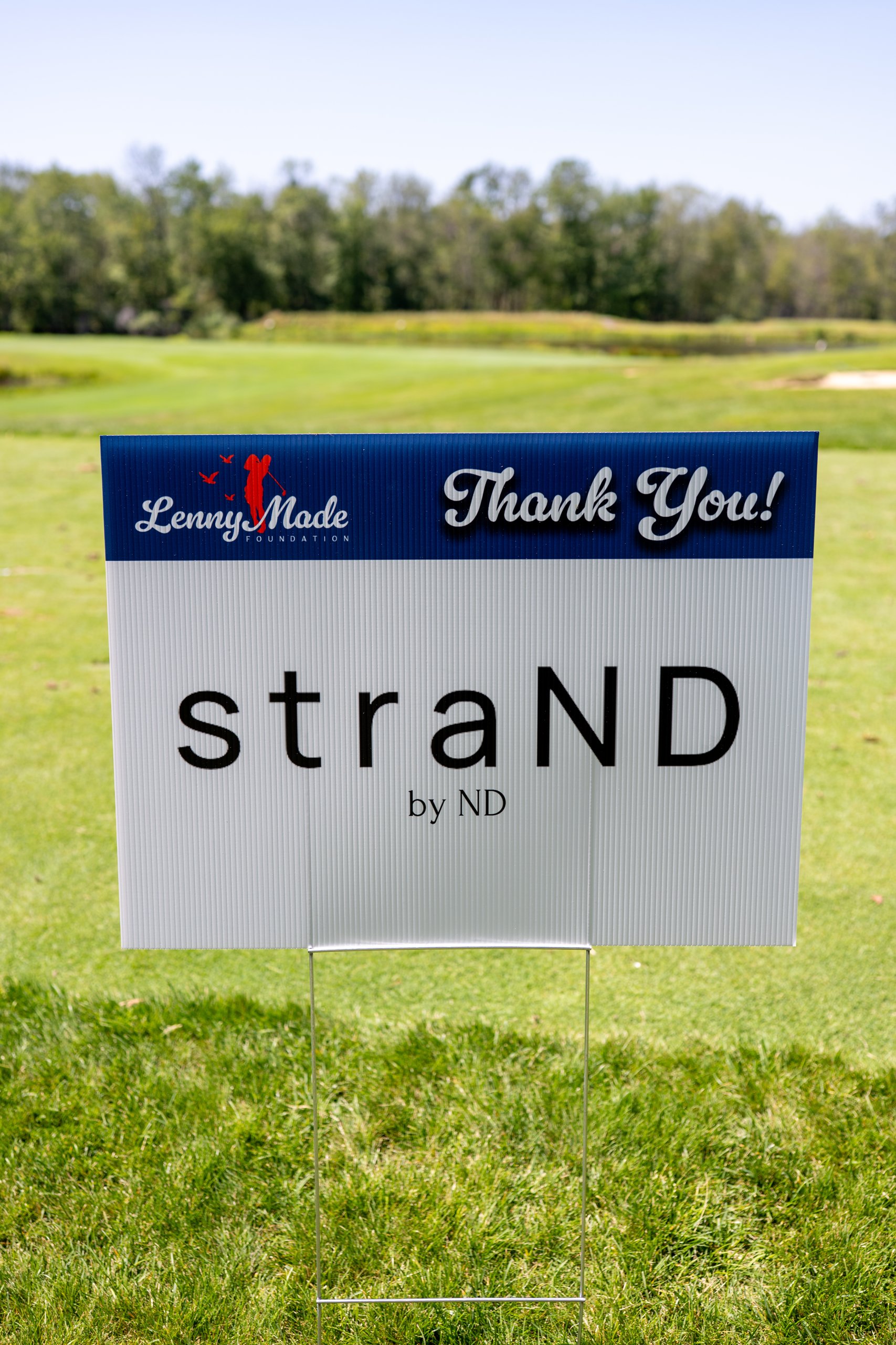 A LennyMade Foundation Thank You sponsor sign for straND by ND on the course.
