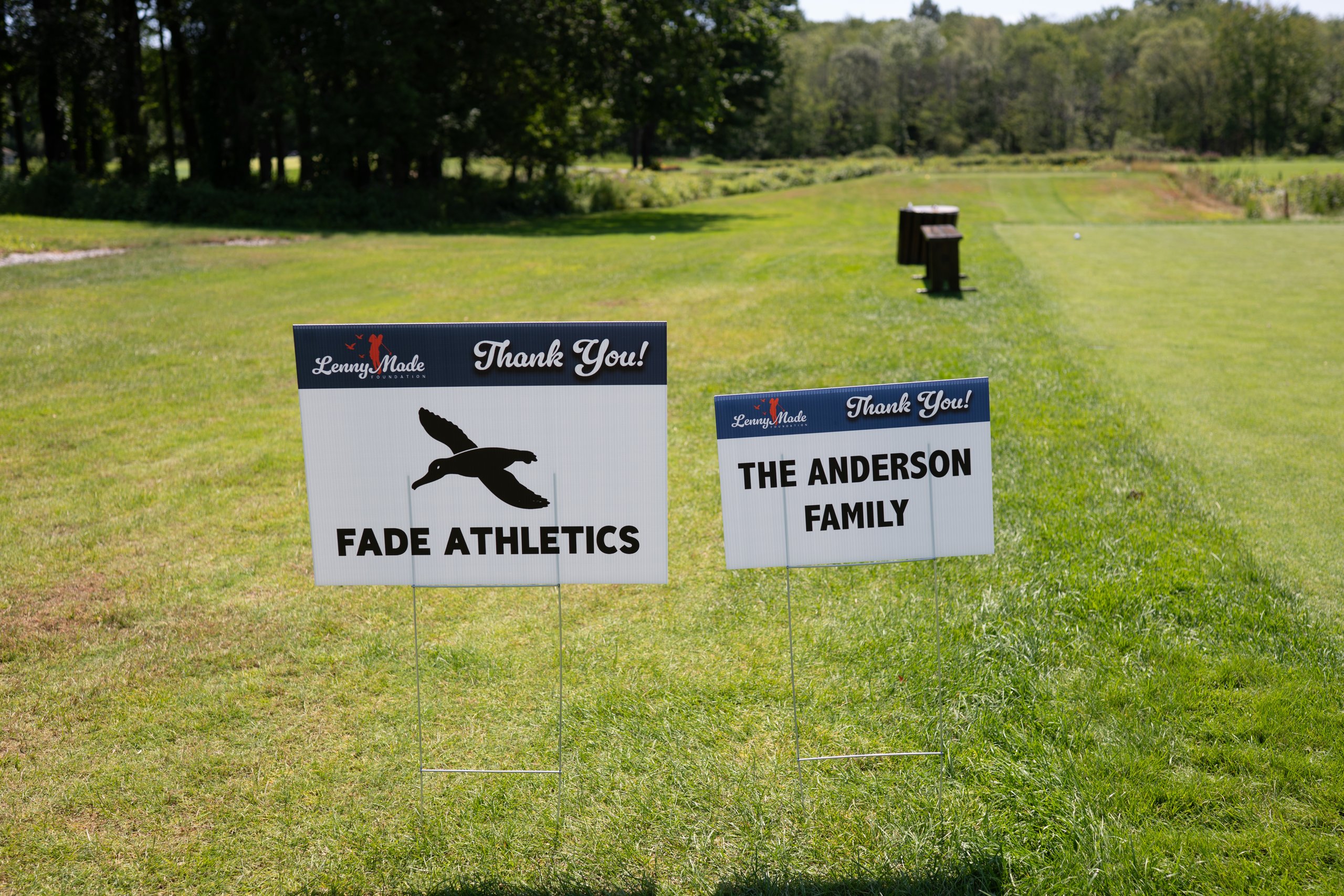 Two LennyMade Foundation sponsor signs on the tee: Fade Athletics and The Anderson Family.