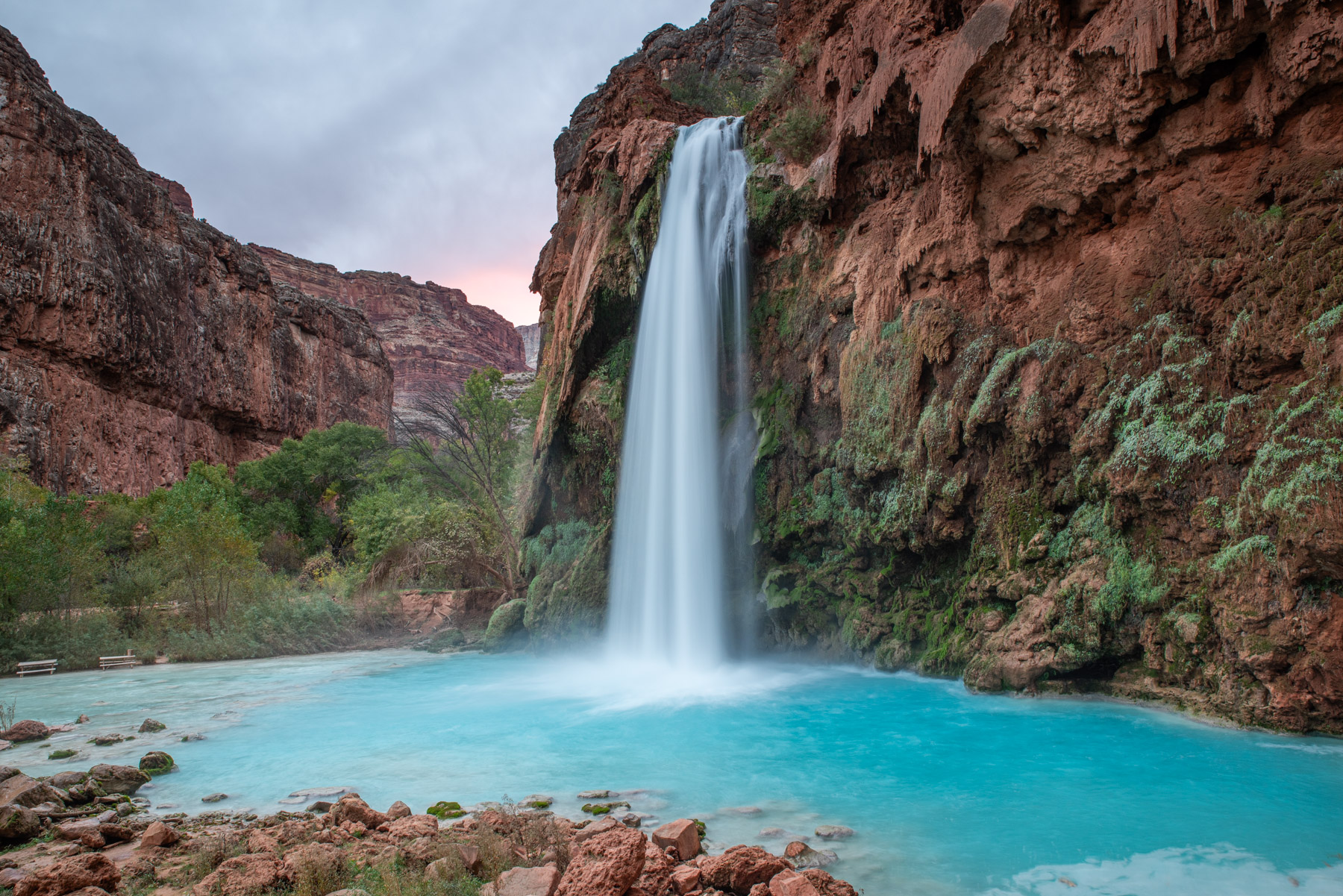 Havasu Falls in the early morning with the sunrise blushing in the back.