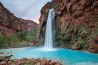 Havasu Falls in the early morning with the sunrise blushing in the back.