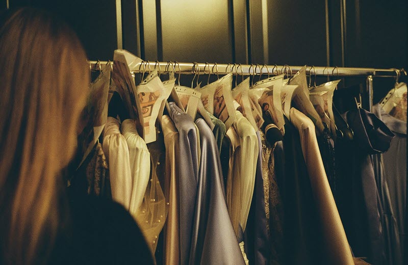Costume rack labelled ahead of a UK background artist fitting.
