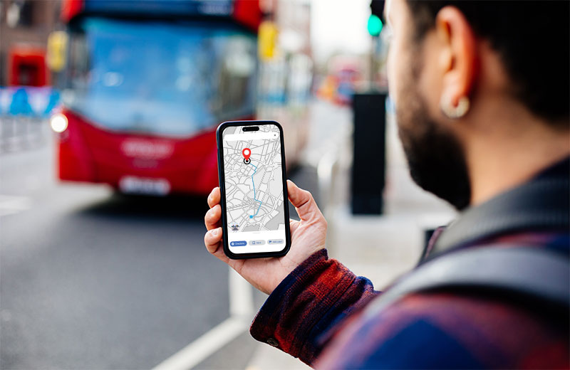 Checking a shoot location on a phone near a London bus stop.