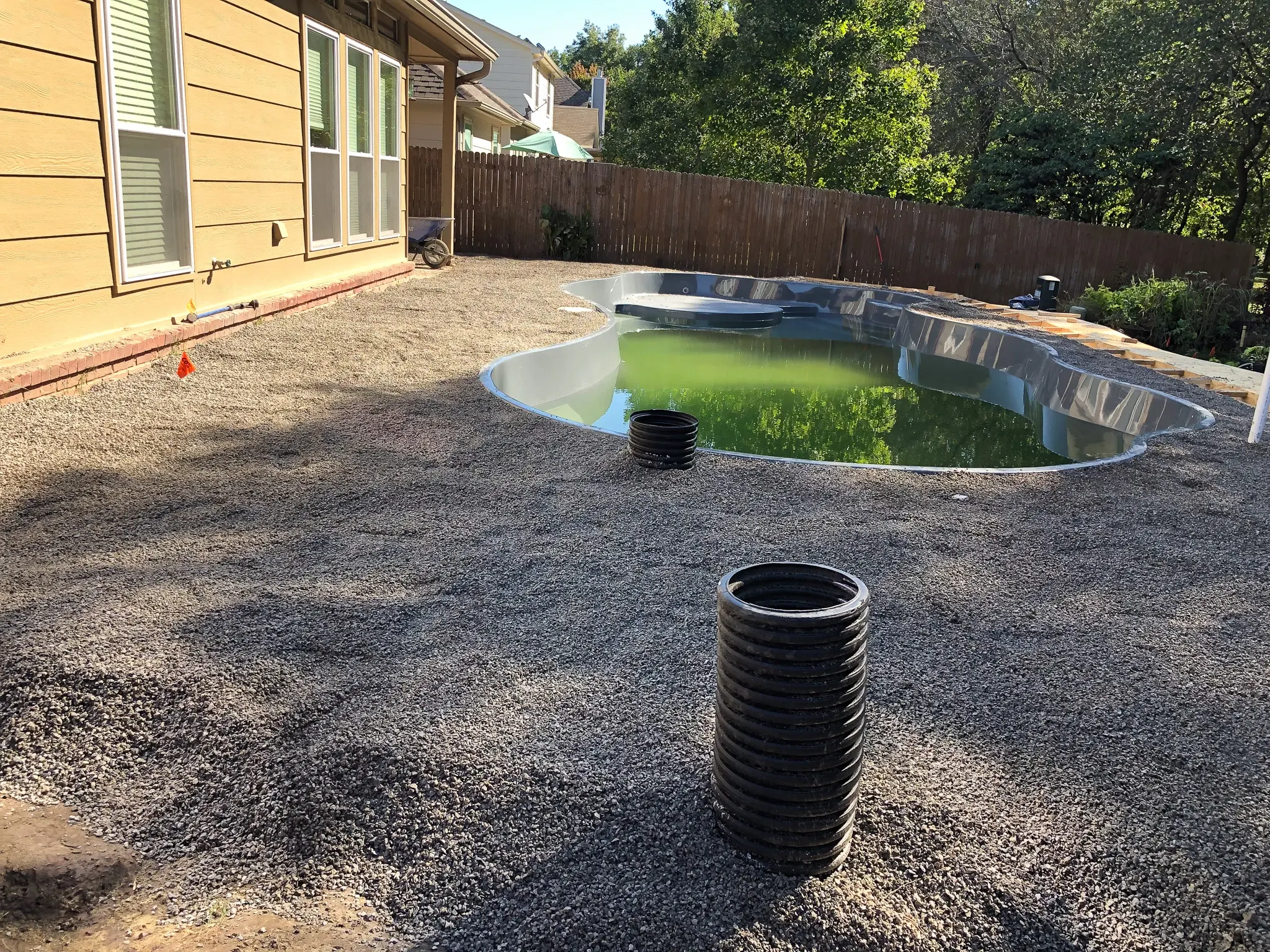 Fiberglass pool with 3/8 chip stone backfill and base in Tulsa backyard.