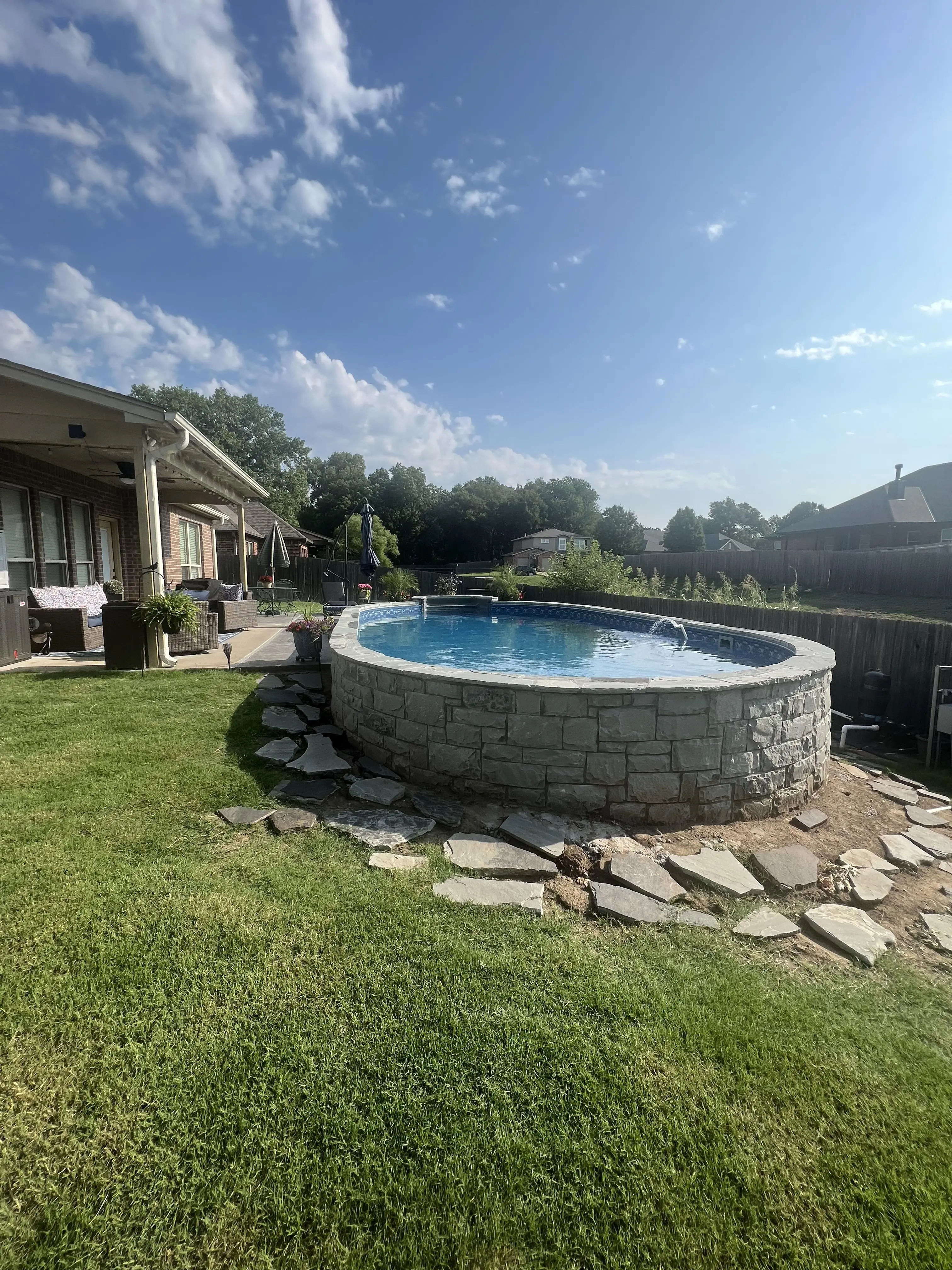 Semi inground swimming pool in sloped yard in Tulsa, OK.