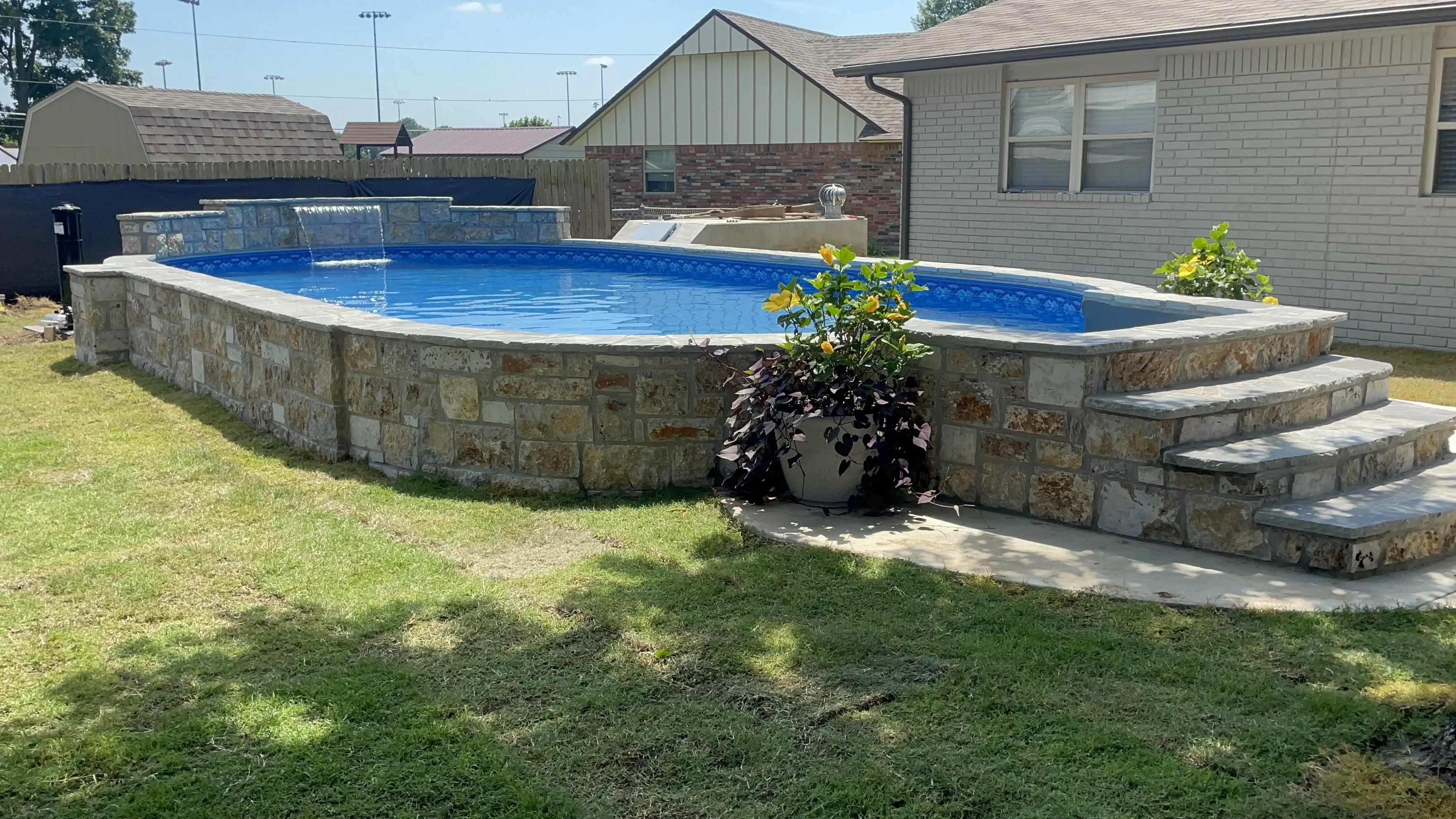 Semi-inground vinyl liner pool with water feater.