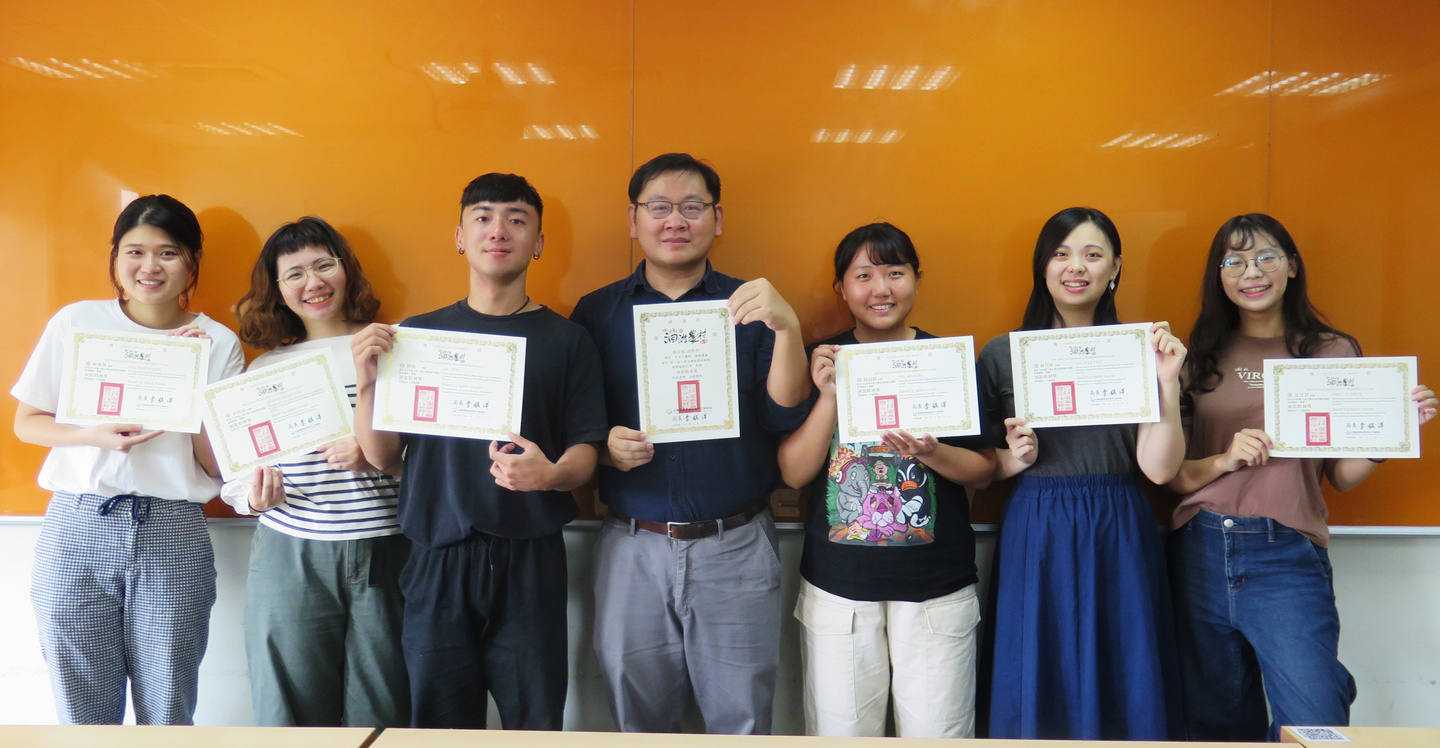設計工作坊成果展示照片，七位學生於黃色背景牆前展示設計成果與作品集