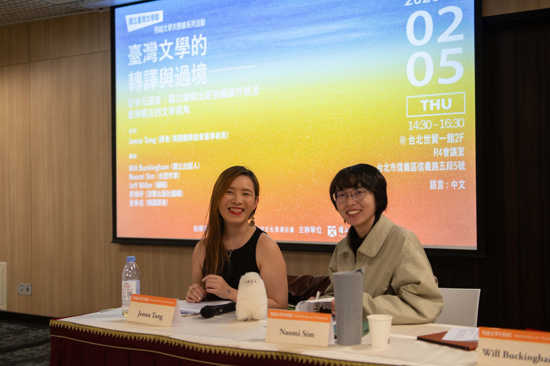 臺灣文學的跨界對話講座活動，兩位講者於舞台前進行專題演講，背景展示活動主題與時間資訊(02月05日 THU)，展現學術交流氛圍